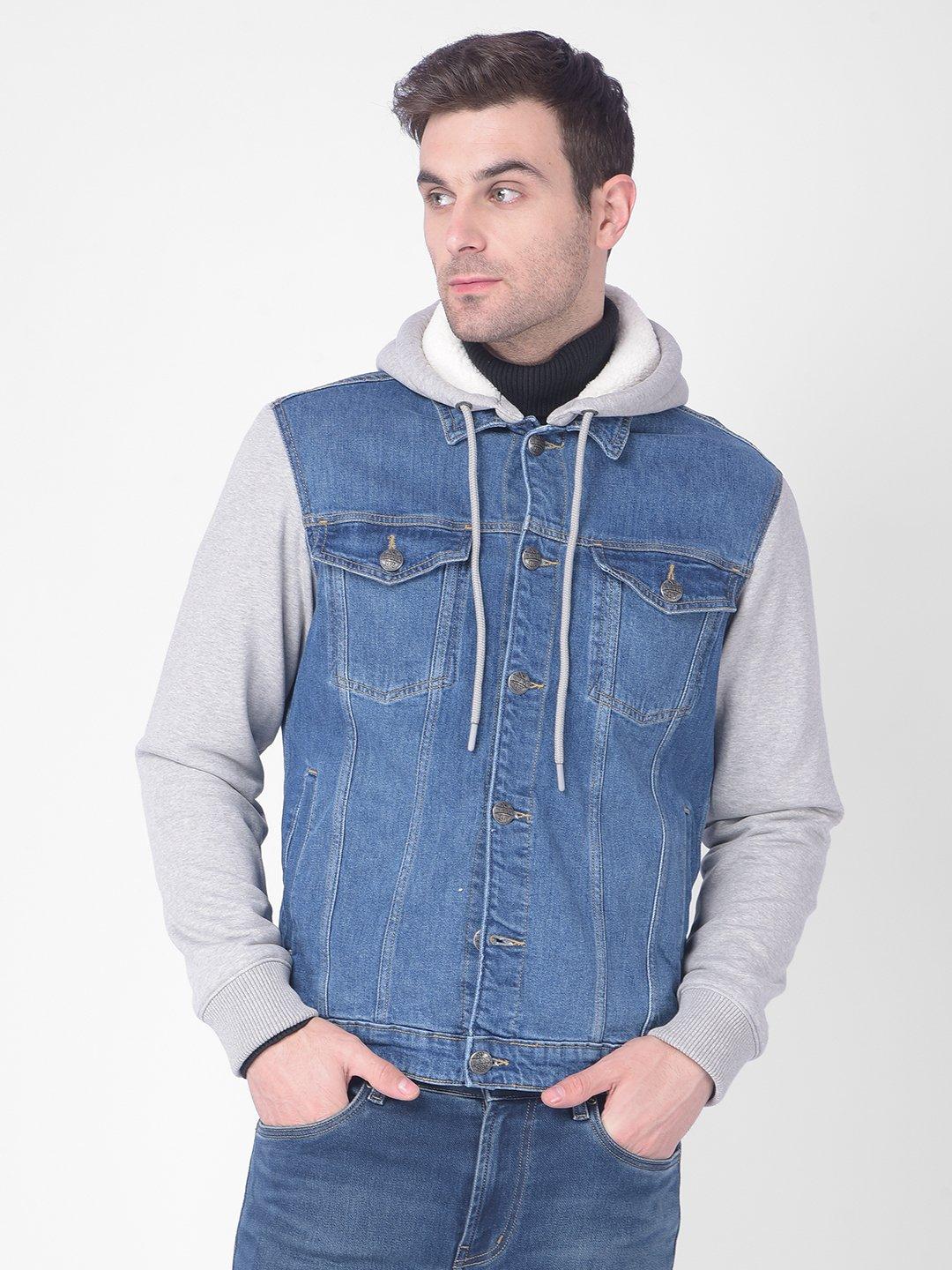 man in blue denim button up vest hoodie and red white plaid long sleeve  shirt with white v neck shirt underneath and black denim pants with black  wayfarer sunglasses by Nic McLaughlin.